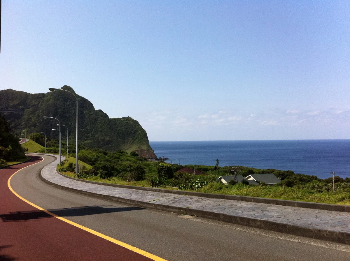 A coastal road tracing the cliffs of Hachijō-jima above the Pacific